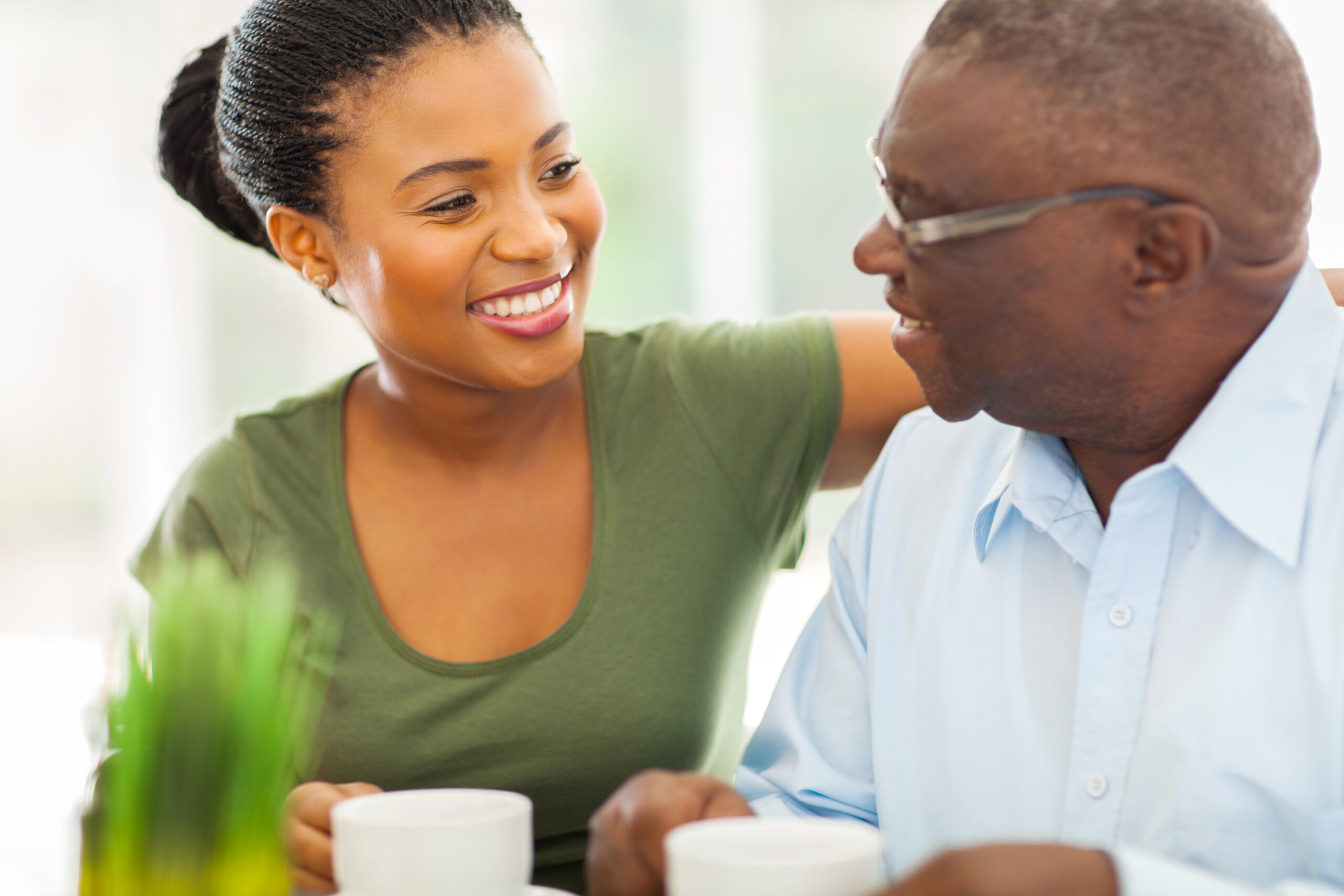 A woman smiling and talking to her father.